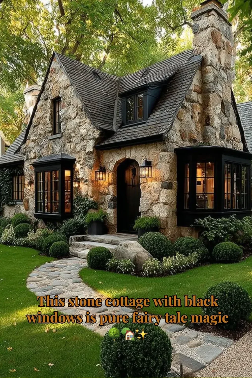 Charming stone cottage with black windows surrounded by lush greenery