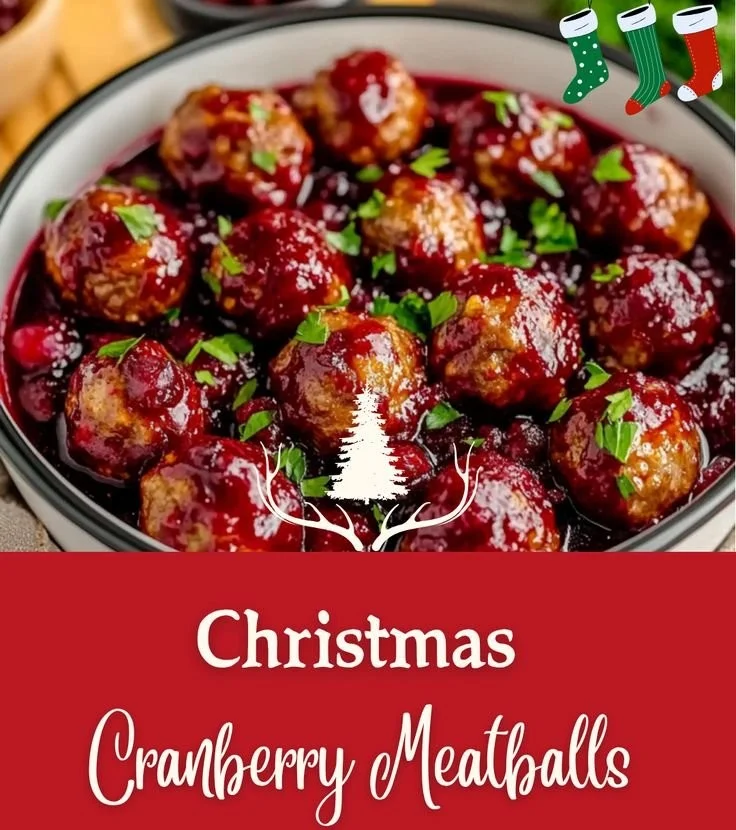Festive Christmas Cranberry Meatballs served on a platter, garnished with herbs.