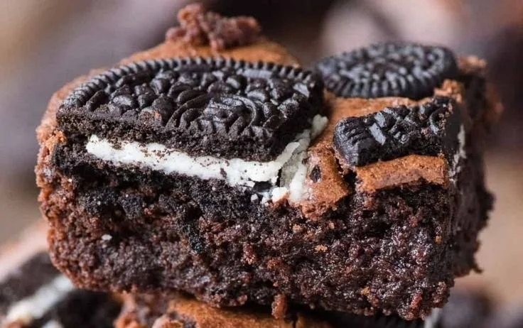 Delicious Oreo Brownies topped with crushed Oreo cookies and chocolate drizzle.