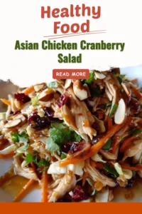 A bowl of Asian Chicken Cranberry Salad with vibrant vegetables and chicken pieces.