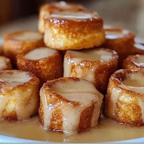 Cinnamon roll french toast bites topped with icing and fresh berries