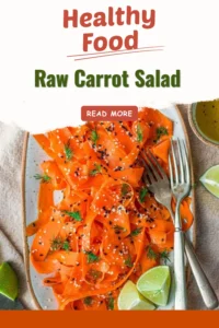 Fresh raw carrot salad with herbs and dressing on a plate.