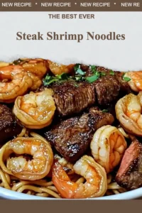 Delicious Steak Shrimp Noodles dish served on a plate with fresh vegetables.