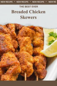 Golden breaded chicken skewers served on a plate with dipping sauce.