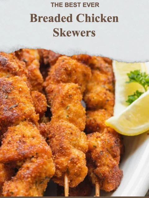 Golden breaded chicken skewers served on a plate with dipping sauce.